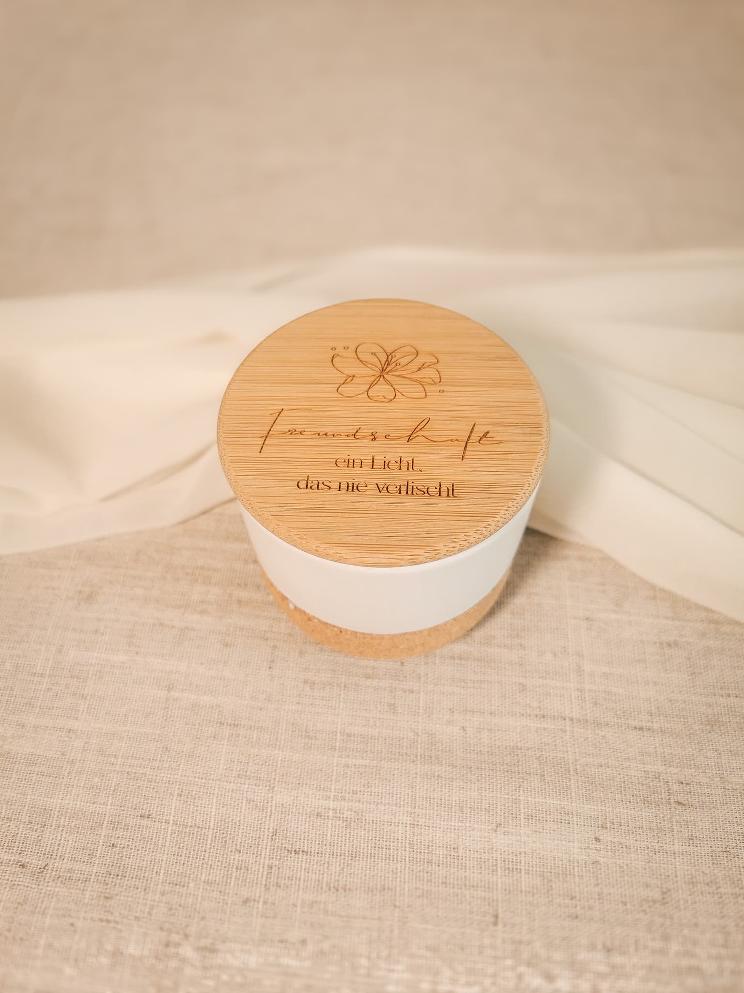 Seitenansicht einer dekorativen Duftkerze – weiße Keramik, natürliche Korkbasis, modernes Design