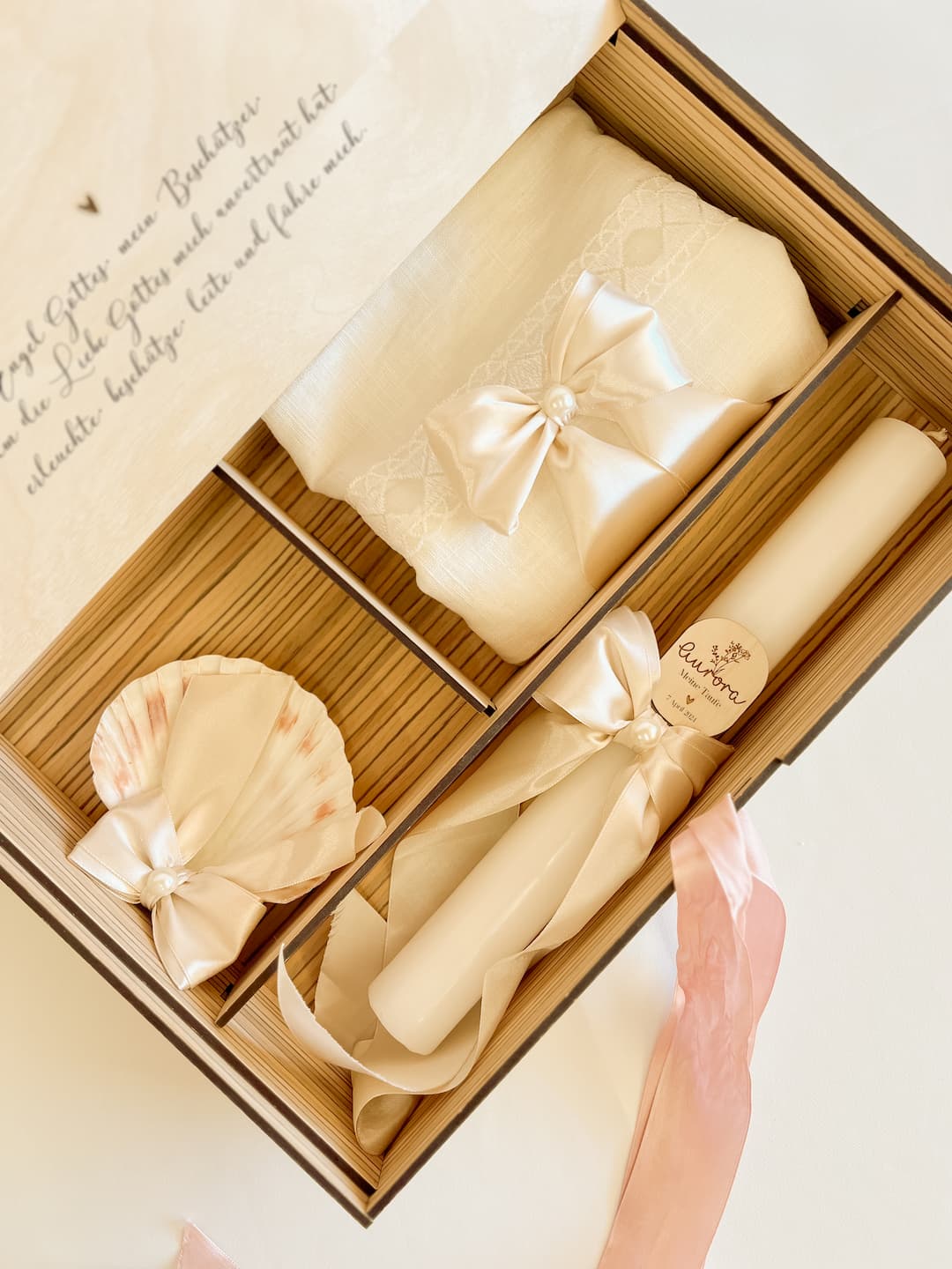 Geöffnete Erinnerungsbox zur Taufe mit Kerze, Taufmuschel und Tauftuch