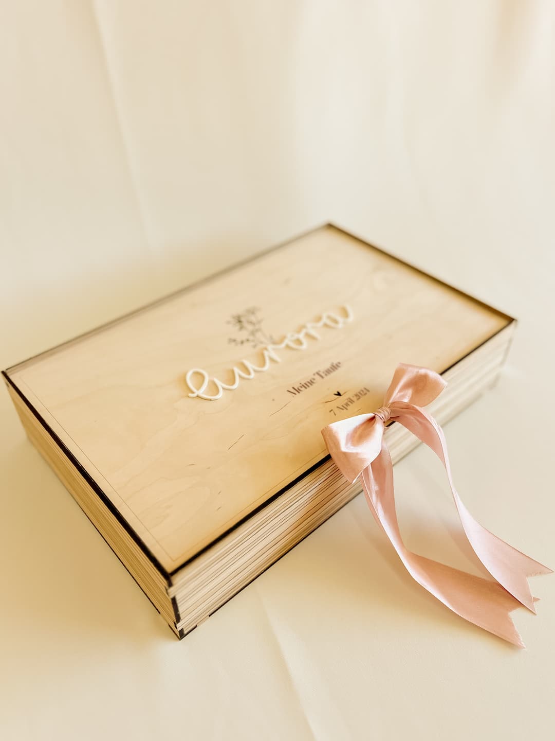 Detailaufnahme des weißen Acryl-Namens auf dem Deckel der Taufbox